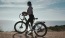 a woman standing next to a bicycle